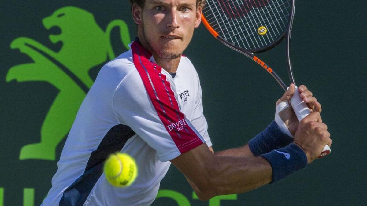 Pablo Busta returns the ball to Kevin Anderson during the Miami Open tennis tournament in Key Biscayne, FL, Thurs., March 29, 2018.
