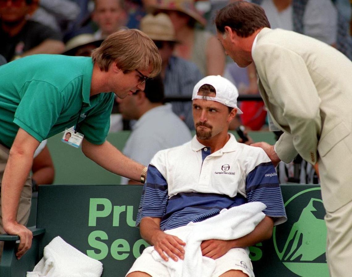 Goran Ivanisevic is attended to by Lipton Tennis officials during the first set, immediately after announcing that he would forfeit the championship match against Andre Agassi because of an injury on March 31, 1996.