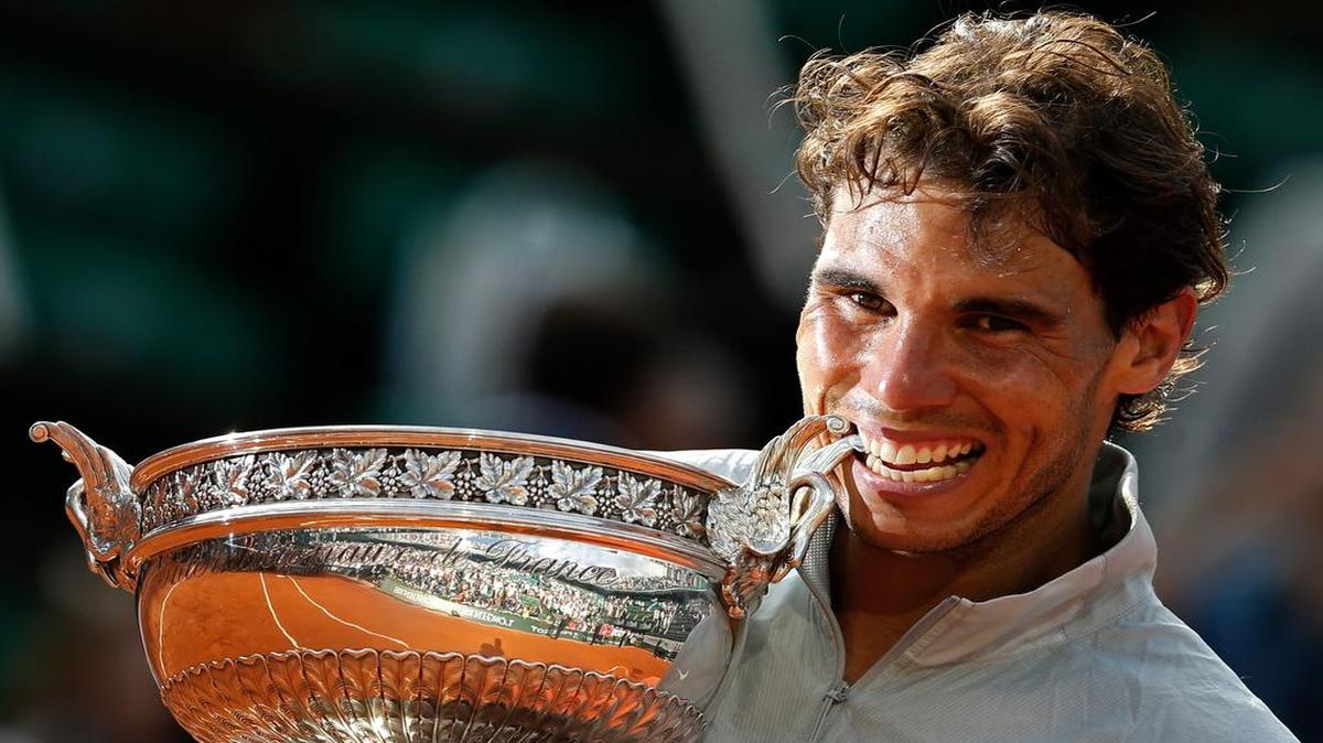 Rafael Nadal bites the trophy after winning the men’s singles final of the French Open against Novak Djokovic in 2014, his ninth title at Roland Garros.