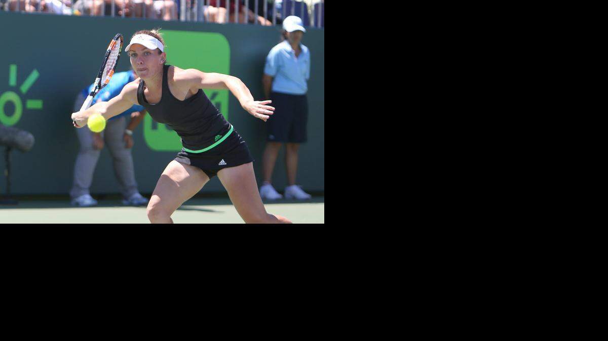
Simona Halep, from Romania, returns the ball to Camila Giorgi, from Italy, during their third round match at the Day 7 of the Miami Open tennis tournament at Crandon Park in Key Biscayne on Sunday, March 29, 2015.
