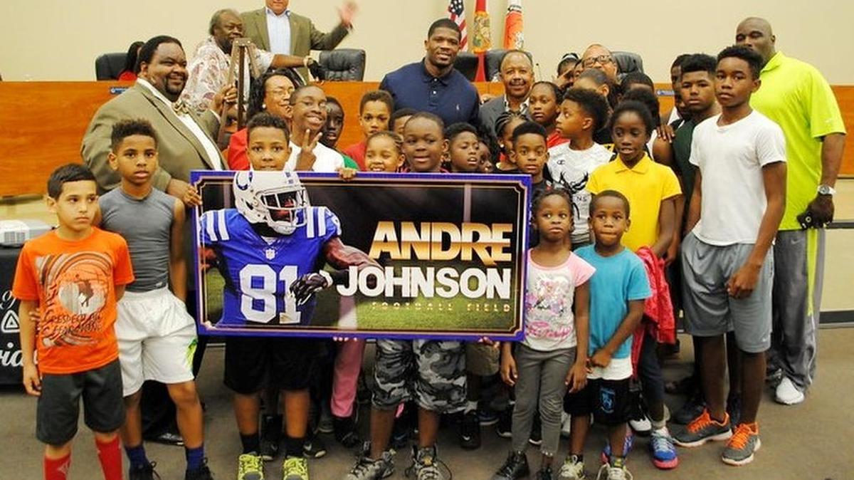 Standout college and NFL receiver Andre Johnson shows the new scoreboard sign created for the football field at Opa-locka’s Ingram Park. A Miami Senior High School grad, he is surrounded by community youth, his former coaches and Opa-locka Commission members including Coach/Commissioner Joseph L. Kelley, Vice Mayor Timothy Holmes, Commissioner Luis B. Santiago, Ed Brown, Commissioner Terence K. Pinder and Coach Andre Whittle. The sign will receive a makeover to change Johnson’s jersey to one he wore with the University of Miami.
