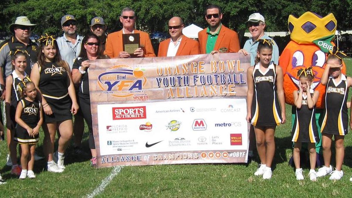 
PARK OF THE WEEK: The Orange Bowl Youth Football Alliance, presented by Sports Authority, visited five sites in Miami-Dade County to kick off the 2015 Park of the Week Program. The program recognizes select youth football parks across South Florida each Saturday during the fall to show its continued support of the community. Pictured are Orange Bowl committee members Andy Haggard, Albert de Cardenas and Xavier Gonzalez, along with Mitch Panter of Panter, Panter & Sampedro P.A., members of the Kendall Boys and Girls Club Kolts and Orange Bowl mascot Obie.
