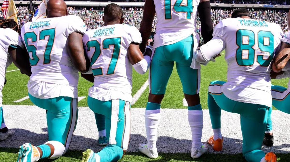 Laremy Tunsil, Maurice Smith and Julius Thomas kneel with Jarvis Landry of the Miami Dolphins during the National Anthem prior to an NFL game against the New York Jets at MetLife Stadium on Sunday.